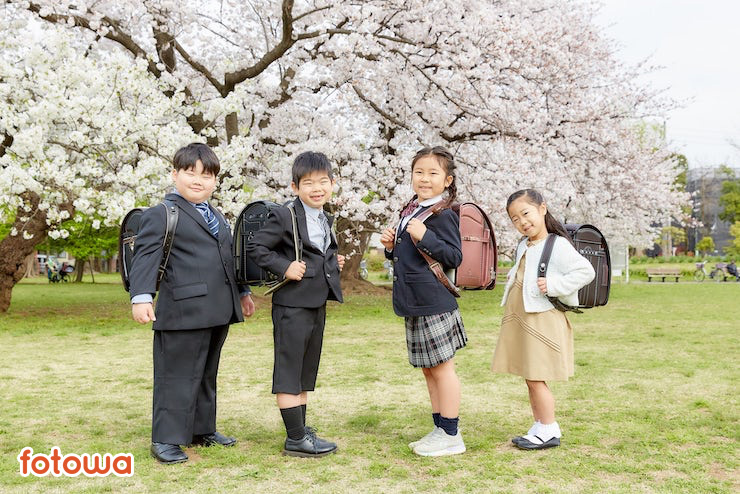 桜の前でランドセルを背負った子ども4人